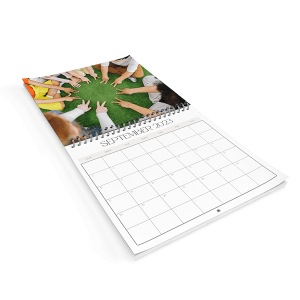 Spiral wall calendar with students' hands photo