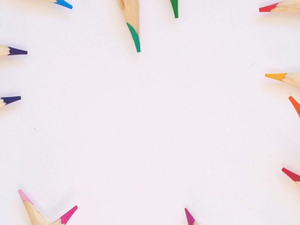 Photograph of tips of colored pencils   around the border with white space in the center.