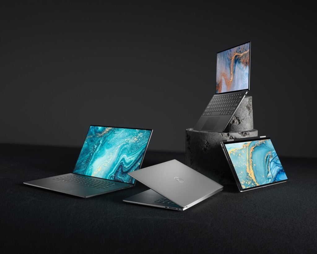 open laptops with marble screen savers on a black background