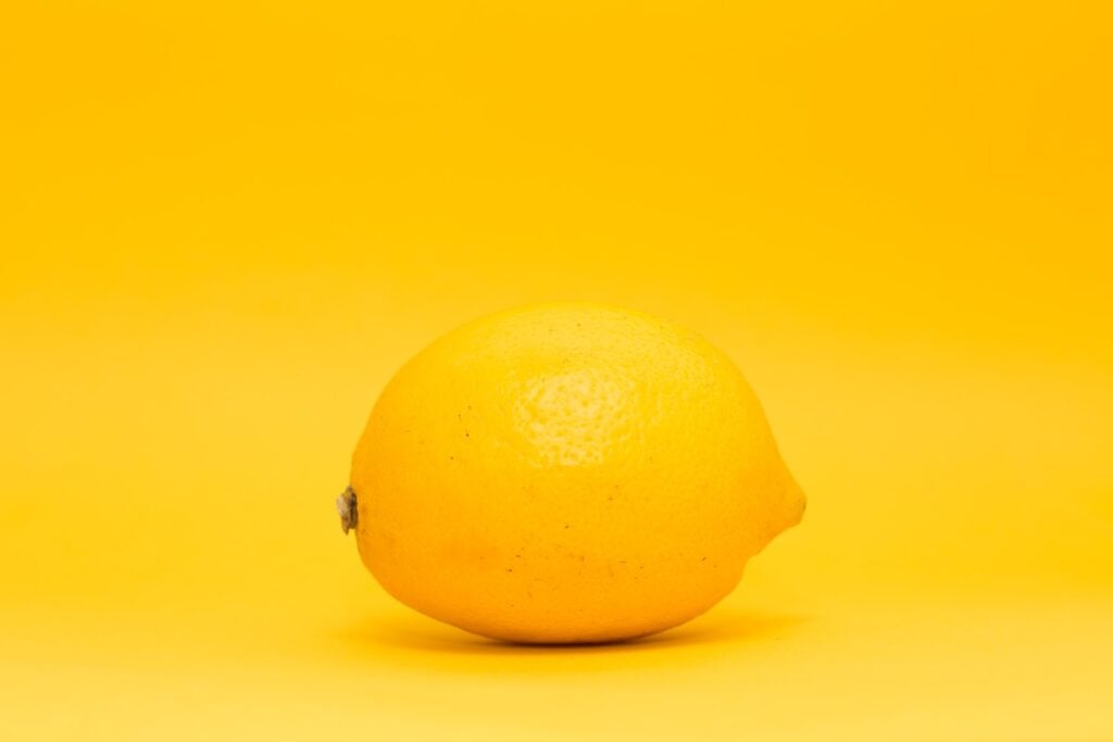 Yellow lemon on a yellow monochrome backdrop