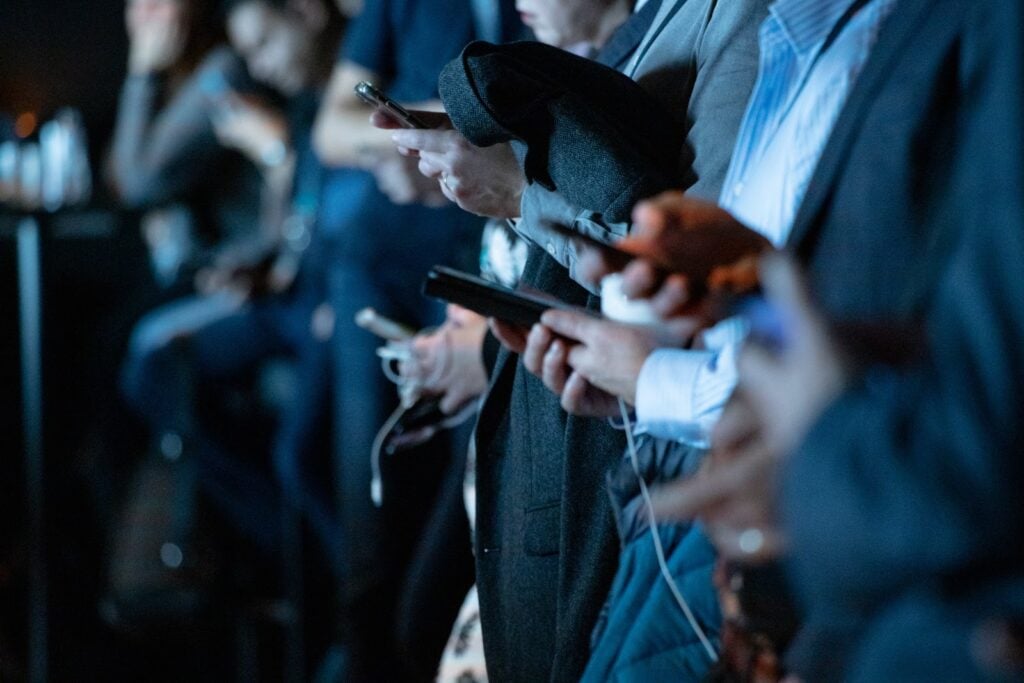 people in a line holding phones