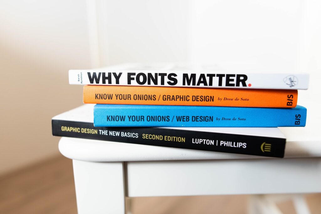 Books about fonts and graphic design stacked on top of a table