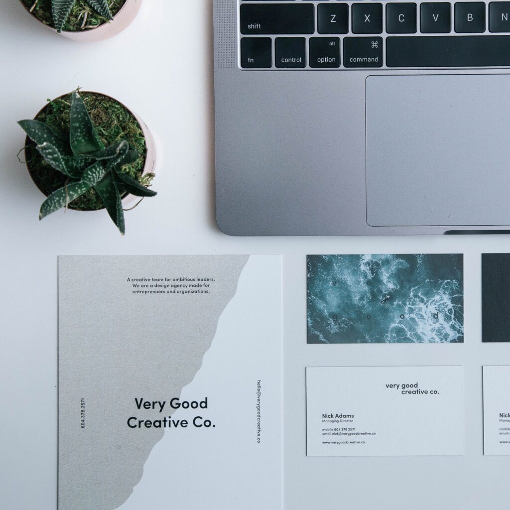 Laptop next to printed flyers and business cards