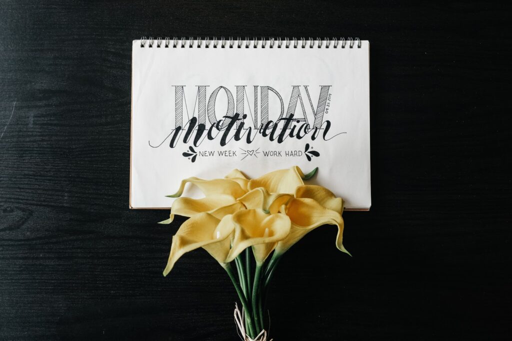Notebook with written lettering on a black table with flowers