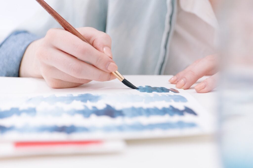A person painting blue design