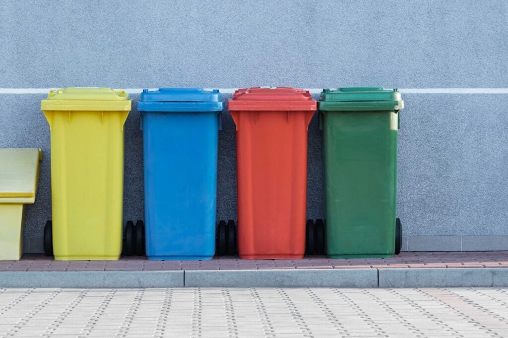 Trash and recycling cans next to each other