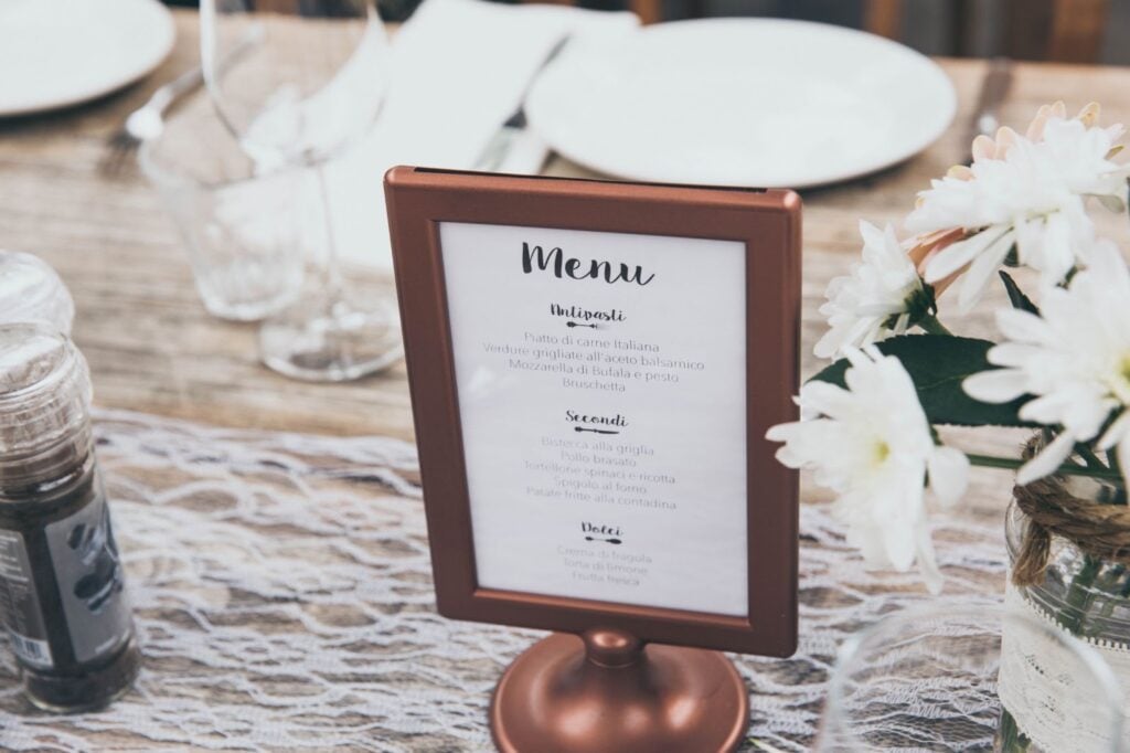 Catered menu in a stand on a decorated table