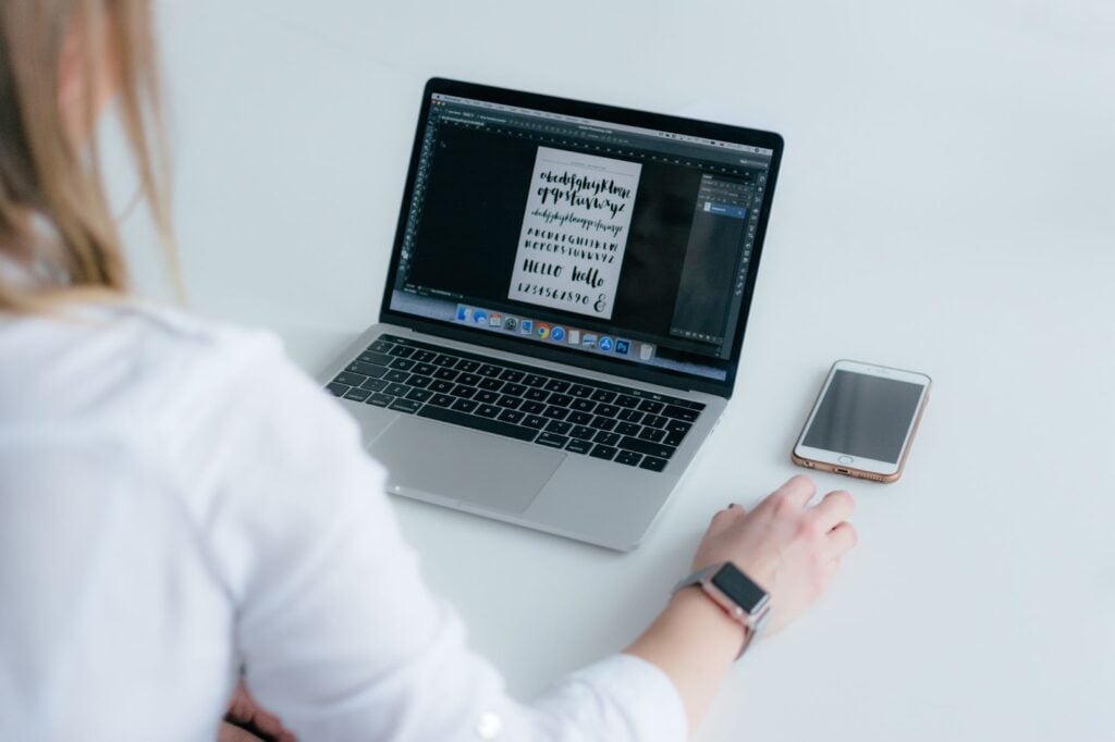 Person on laptop with fonts open on Photoshop