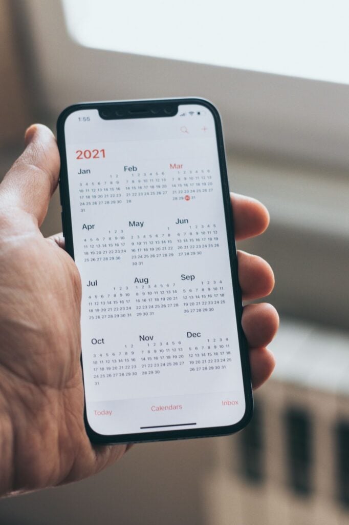 Hand holding phone with calendar app open