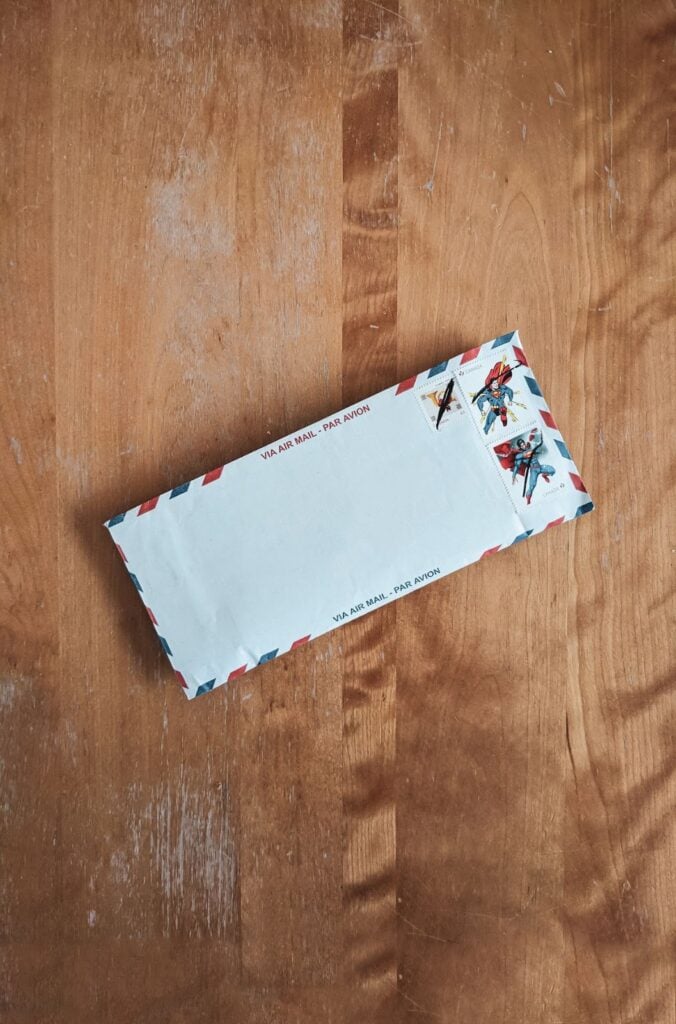 Envelope with three stamps on wood table