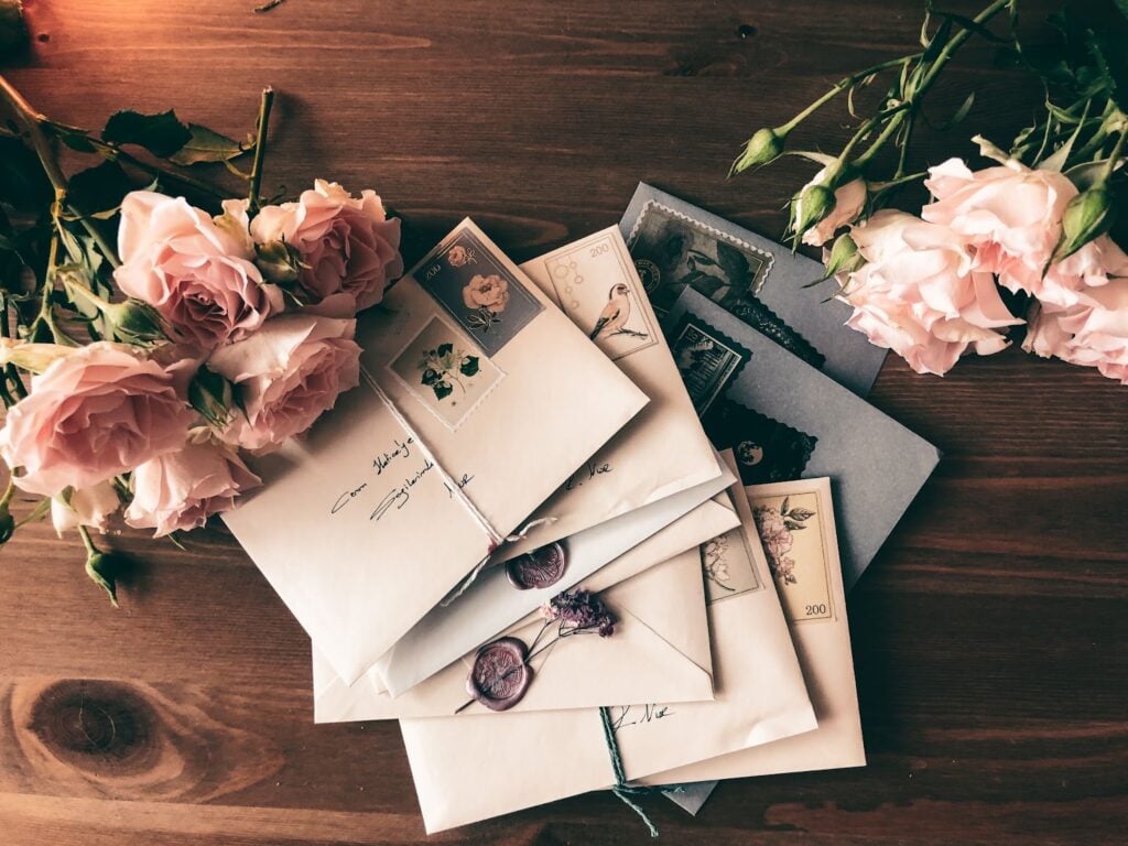 Envelopes tied and stamped on a table with flowers