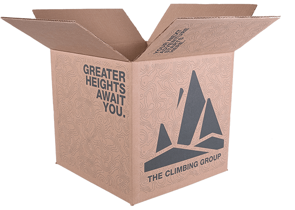 Open cardboard box with mountain logo, 'Greater Heights Await You,' and 'The Climbing Group' text on a topographic background.